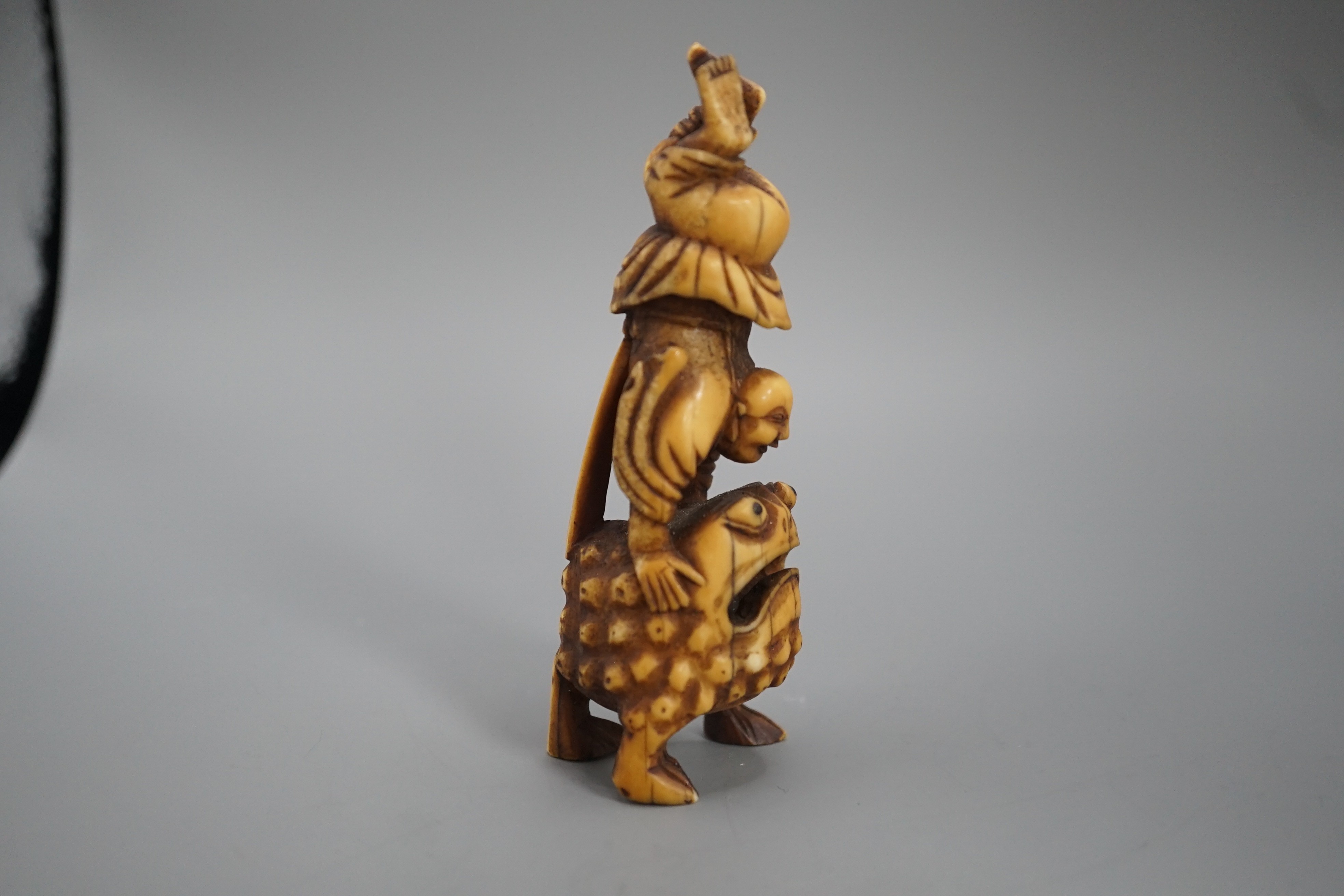 A 19th century Chinese or Japanese carved walrus ivory figure of Liu Hai balancing on his three legged toad, 9cm